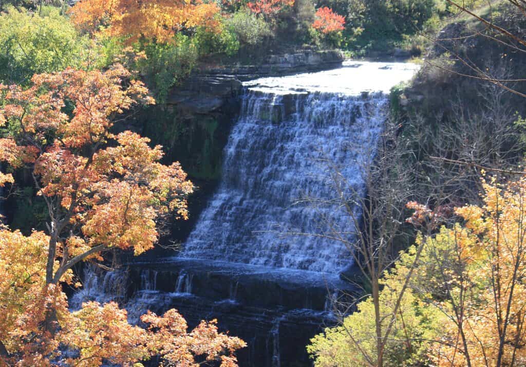 a wide sheet waterfall falling gently over the edge of the niagara escarpment in hamilton ontario