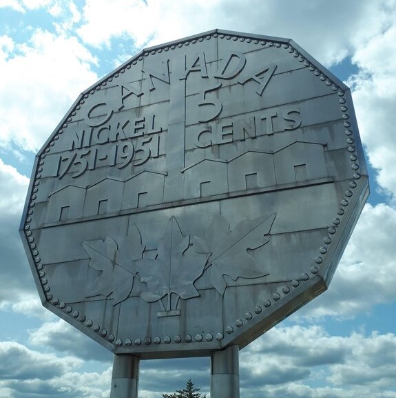 a large statue of a canadian nickel against a cloudy sky in sudbury ontario