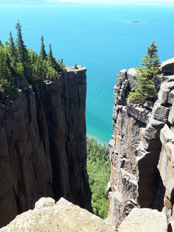 view of Lake Superior between a drop off in the cliffs at the Top of the Giant trail in Sleeping Giant Provincial Park