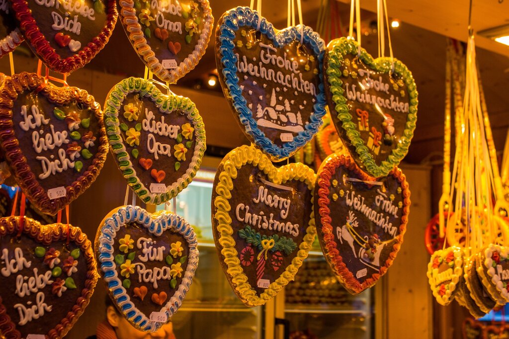 decorated gingerbread hearts hanging above a vendor hut at a christmas market
