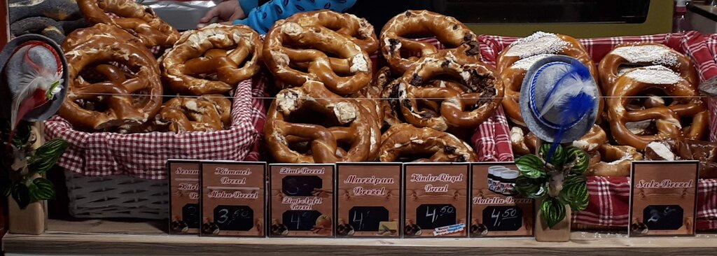 different types of pretzels in baskets with red and white material underneath for sale in a European christmas market