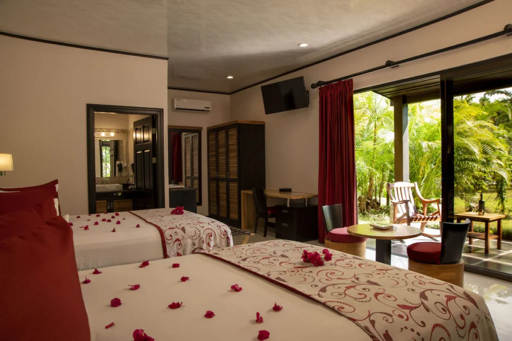 two beds in hotel room with glass door to patio in la fortuna Costa Rica