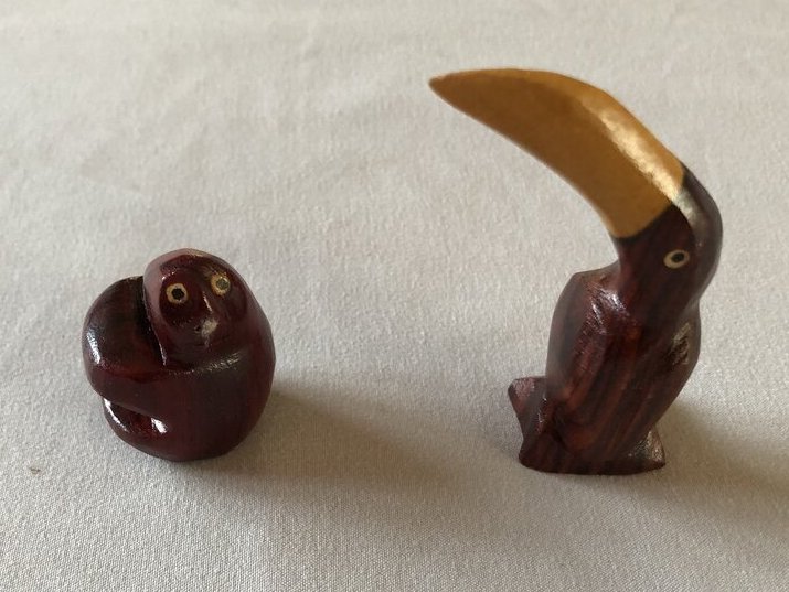 a carved wooden sloth and a carved wooden toucan - carved wooden figurines are a popular souvenir from Costa Rica