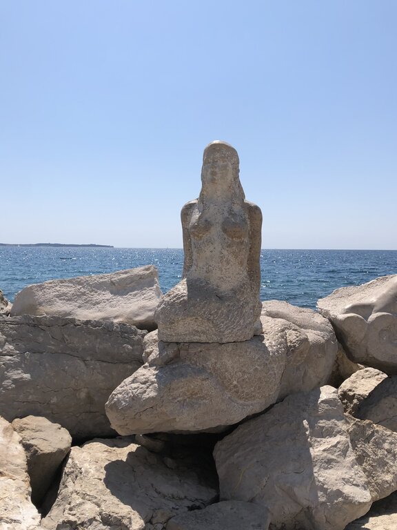 stone carved into a statue of a mermaid in piran Slovenia