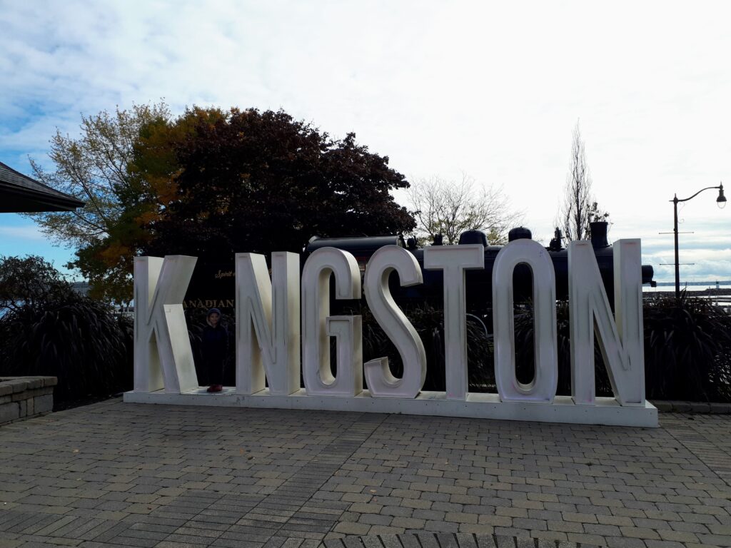 large white letters spelling kingston stands in cobblestone plaza in downtown kingston